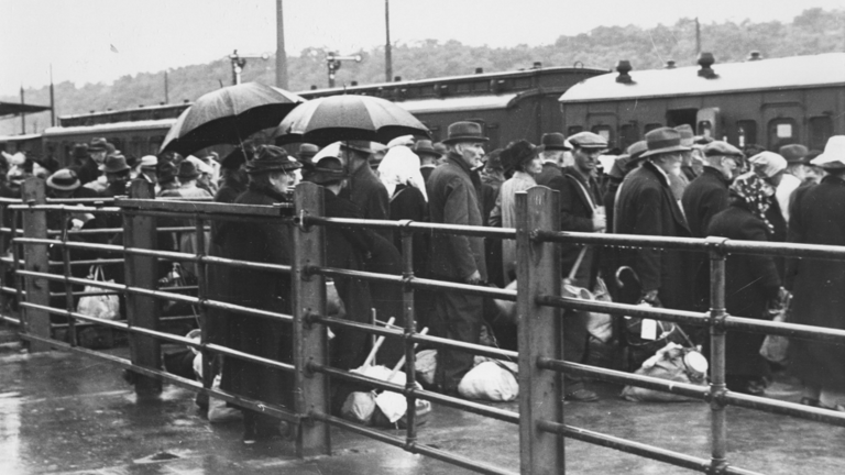 Historisches Foto: Alte Männer und Frauen steigen in Züge