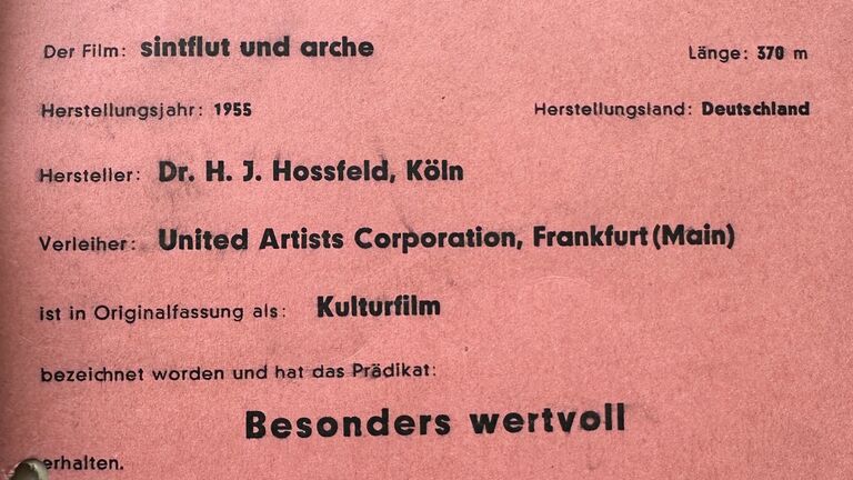 auf einem roten Blatt gedruckt die Bewertung für den Film „Sintflut und Arche“ mit dem Prädikat besonders wertvoll