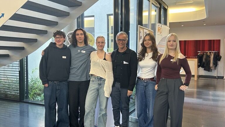 sechs Personen auf einem Foto, drei junge Schüler neben ihrem Lehrer, daneben wieder zwei junge Schülerinnen