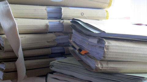 Justizakten auf einem Schreibtisch gestapelt