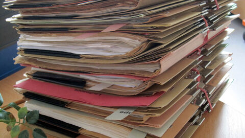 gestapelte Akten auf einem Schreibtisch