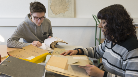 Zwei Auszubildende für Fachangestellte für Medien- und Informationsdienste beim Erschließen von Akten.