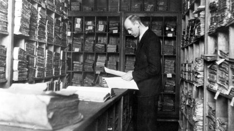 Archivar bei der Recherche, um 1940 (HHStAW) Blick in einen historischen Magazinraum des Staatsarchivs Wiesbaden: Archivar bei der Recherche, um 1940 (HHStAW)