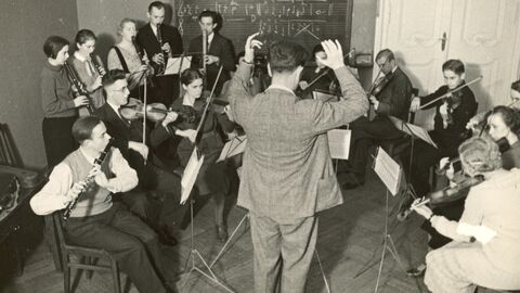 Der "Blitzkreis" der Jugendmusikschule Berlin-Charlottenburg musiziert mit H. Reichenbach, um 1930 (AdJb, A 228, 4346) Historisches Foto: Jugendliche und junge Erwachsene musizieren auf Streich- und Blasinstrumenten (AdJb, A 228, 4346)