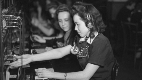 Historisches Foto: Eine Telefonistin des Fernsprechamts an ihrem Arbeitsplatz vor dem Schaltschrank, 1948 (HHStAW, 3008/2, 17244)