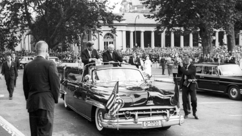 Historisches Foto: John F. Kennedy und Ludwig Erhard stehend in einer offenen Limousine bei der Ankunft vor dem Kurhaus in Wiesbaden, 1963 (HHStAW, 3008/47, 4075)