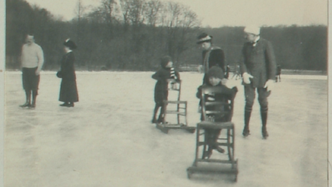 Historisches Foto: Georg Donatus von Hessen und sein Bruder benutzen Stühle mit Kufen als Stütze beim Eislaufen, im Hintergrund vier Erwachsene (HStAD, D 27 A, 76/367-368)