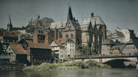 Historisches Foto: Blick über die Lahn auf die Weidenhäuser Brücke, die Universität und das Schloss in Marburg. Farbfoto von Georg Mylius, 1910 (HStAM, Slg 7, f 23/12)