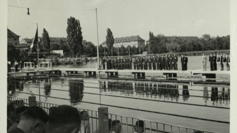 Historisches Foto: Die Schimmmannschaften stehen aufgereiht auf einem Steg neben dem Schwimmbereich
