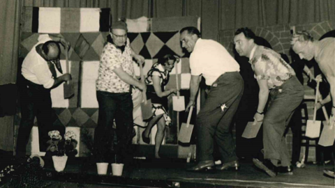 Aufführung des Lehrerkabaretts (HStAD, N 29, 31) Historisches Foto: Kostümierte Männer und Frauen mit Spaten bei einer Theateraufführung auf der Bühne