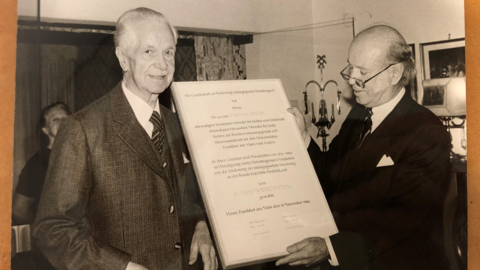 Dr. Erwin Stein beim Erhalt einer Ehrenurkunde (HHStAW) Historisches Foto: Zwei ältere Herren im Anzug, einer überreicht dem anderen eine Ehrenurkunde