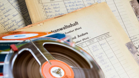 Tonbandspule und Aktenordner mit handschriftlicher Aufschrift