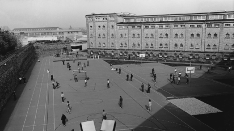 Historisches Foto: Blick in den Hof des Gefängnishof der Justizvollzugsanstalt Butzbach; im Hof Insassen beim Sport, rechts im Hintergrund das Gebäude der Justizvollzugsanstalt