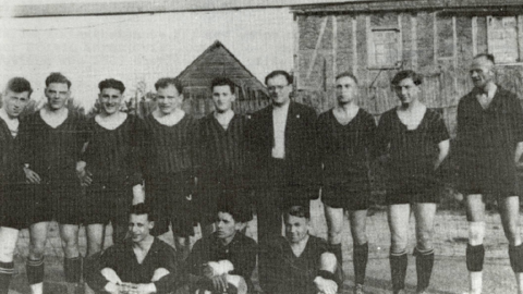 Historisches Gruppenfoto: Männer in Fußballkleidung, eine Reihe stehend, davor drei sitzende