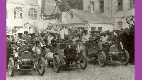 Empfang der Sieger der Prinz-Heinrich-Fahrt in Rüsselsheim, 1909 (HstAD, R 4, 12697) Historisches Foto: Männer sitzen in einer Reihe blumengeschmückter Rennwagen, dahinter viele Zuschauer