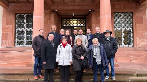 Insgesamt fanden zwei Workshops mit Vertreterinnen und Vertretern der Initiativen, der Landeszentrale für politische Bildung sowie des Hessischen Landesarchivs im Staatsarchiv Marburg statt. Hier zu sehen das Gruppenfoto vom ersten Workshop im November 2023. Eine Gruppe von Männern und Frauen steht für ein Foto zusammen auf den Stufen eines Gebäudes