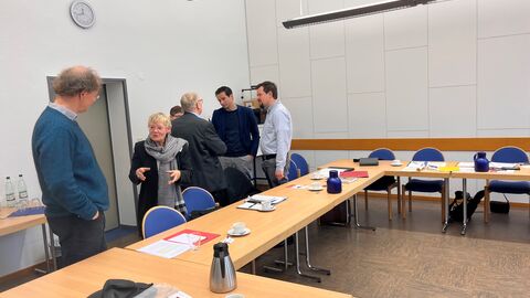 Auf den Workshops wurde rege über den Umgang mit den Sammlungen diskutiert.  Eine Frau befindet sich im Gespräch mit einem Mann. Im Hintergrund unterhalten sich mehrere Personen