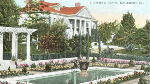 Historische Postkarte: Blick auf einen Garten mit einem blumenumstandenen rechteckigen Wasserbassin, im Hintergrund Palmen und Bäume und eine große weiße Villa mit säulengetragenem Giebel