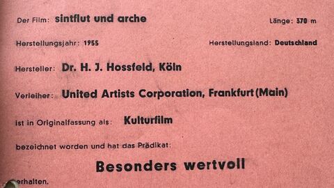 Prädikatsbescheid der Filmbewertungsstelle aus dem Jahr 1955 auf einem roten Blatt gedruckt die Bewertung für den Film „Sintflut und Arche“ mit dem Prädikat besonders wertvoll