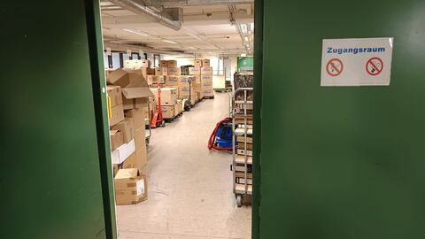 durch eine Tür blickt man in einen Raum voller Kartons