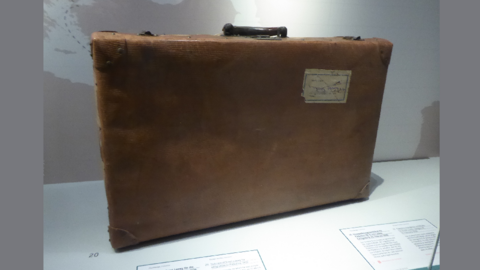 Modernes Foto: Alter Lederkoffer mit einem Aufkleber