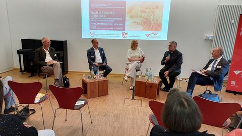 Menschen sitzen in einem Halbkreis und diskutieren