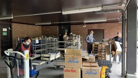 3 Menschen bearbeiten mehrere Kartons