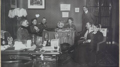 in schwarz-weiß, mehrere Personen sitzen an einem Tisch und essen