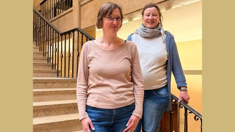 Zwei Frauen stehen nebeneinander auf einer Treppe