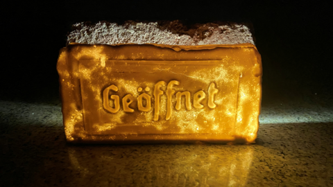 Kunstwerk: Ein beleuchteter Kubus, auf dem in Frakturschrift das Wort "Geöffnet" steht.