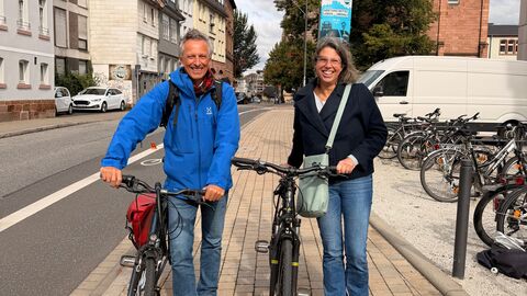 Ein Mann und eine Frau stehen jeweils mit einem Fahrrad in der Hand nebeneinander 
